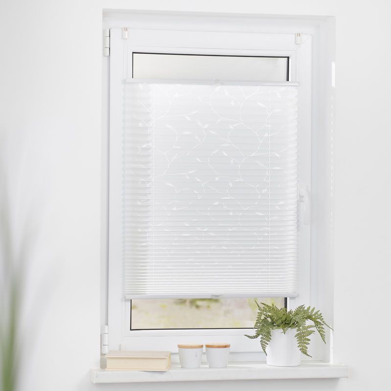 Plissee mit Blumenmuster in weiß angebracht in einen Wohnzimmerfenster