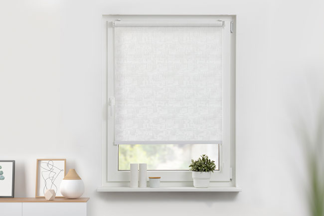 Blickdichtes Rollo in weiß angebracht in einem Fenster