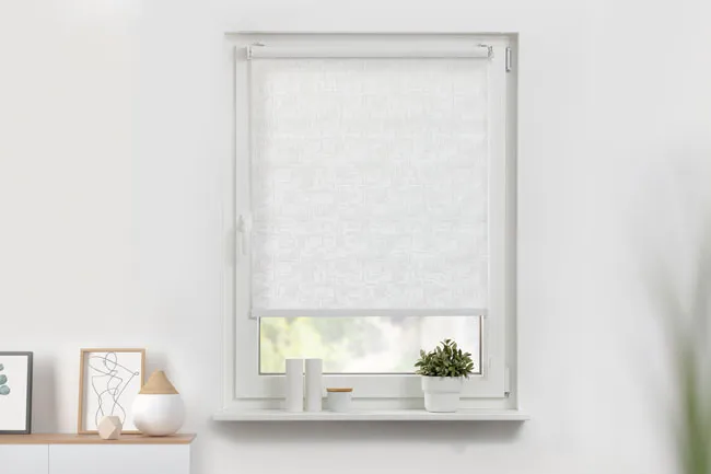 Blickdichtes Rollo in weiß angebracht in einem Fenster