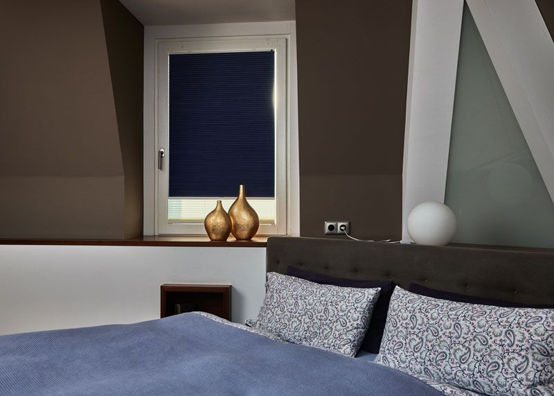 Verdunkelungsplissee in blau angebracht in einem Schlafzimmerfenster