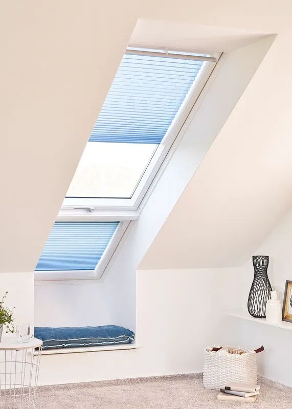 Plissees für Dachfenster angebracht in blau in einen Schlafzimmer