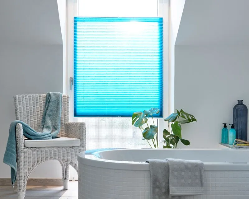 Lichtdurchlässiges Plissee als Sichtschutz in blau in einem Badezimmerfenster
