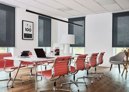 Transparente und lichtdurchlässige Rollos in einem Konferenzraum mit bodentiefen Fenstern